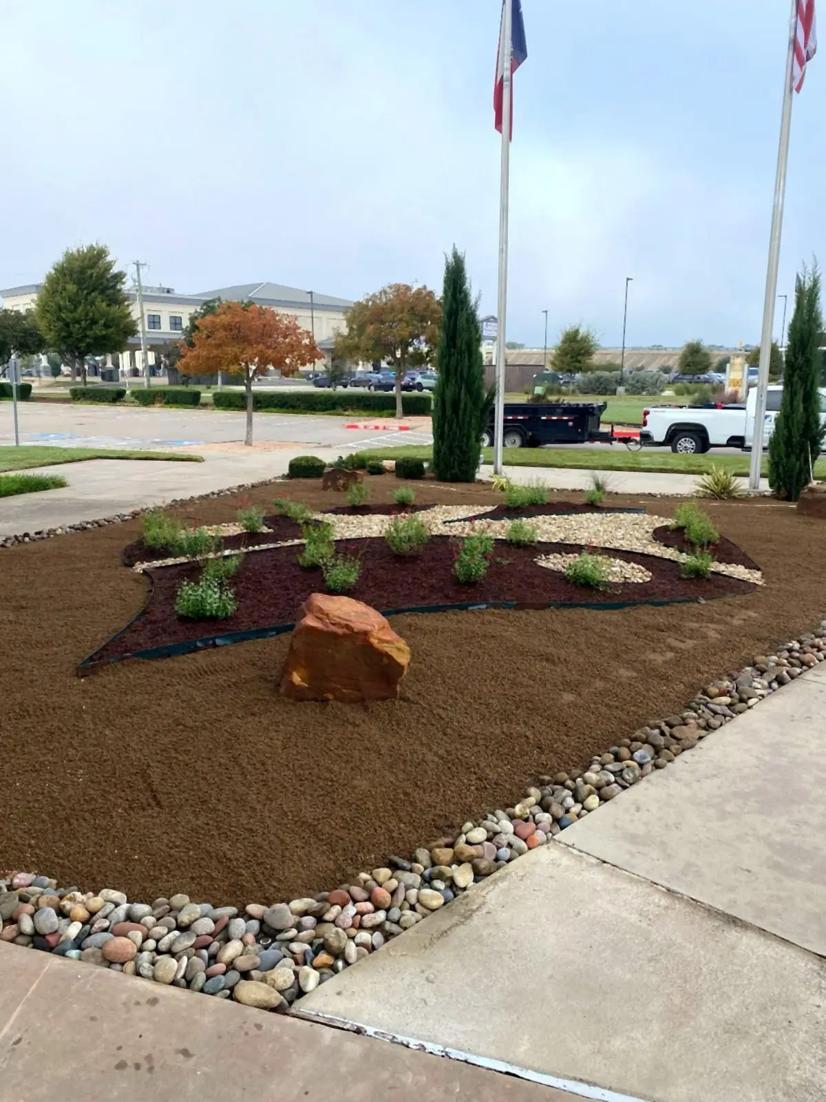 Carter BloodCare landscape design installed by H&M, with shaped beds, river rock, and new plantings.